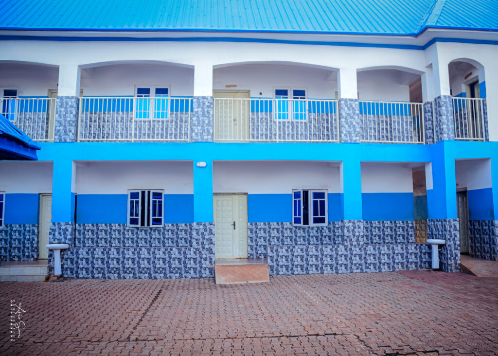 Academic Block – Victory College Campus - Victory College of Health Sciences and Technology Front view of a two-story academic building at Victory College with blue and white exterior, tiled walls, and multiple doors and windows.