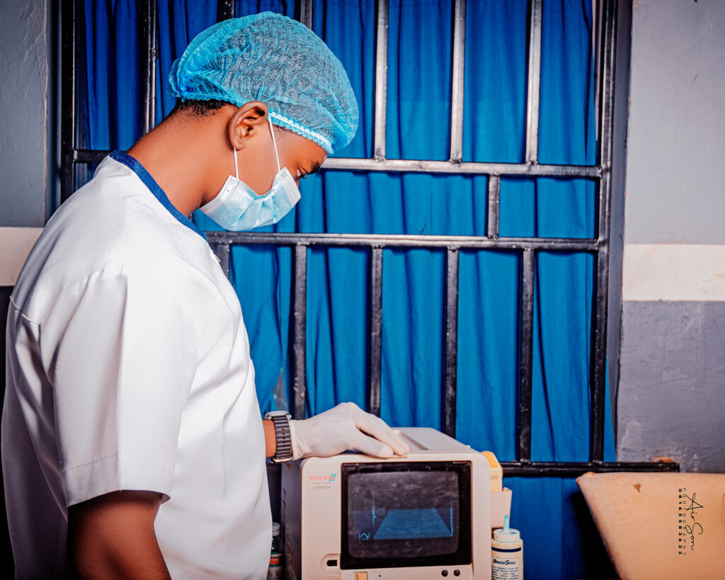 Clinical Equipment Training – Victory College Student in Practice Male student in medical uniform and surgical gear using a diagnostic monitor during clinical training at Victory College.